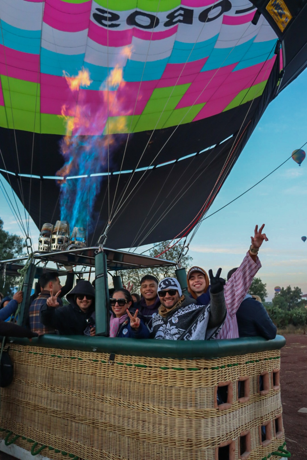 Personas felices y contentas dentro de un globo aerostático México df posando para una fotografía y esperando a que el globo despegue y puedan disfrutar de las alturas.