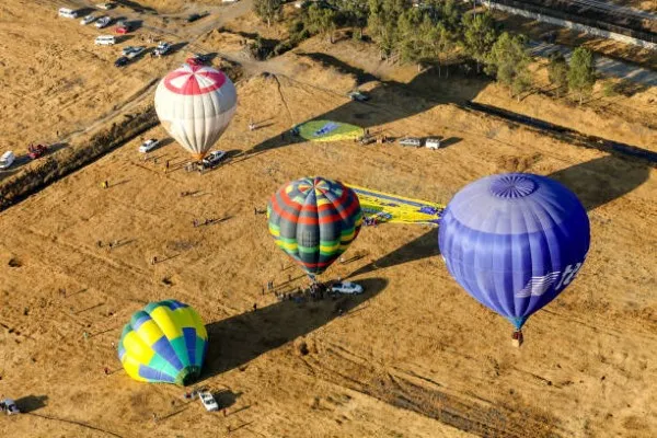 Cuatro tipos de globo aerostático méxico df en diferentes colores, esperando a que los turistas se monten y puedan despegar a los cielos.