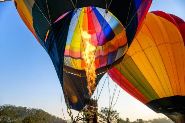 Imagen de un globo aerostático de muchos colores preparándose para flotar y brindar a los turistas la mejor experiencia de un viaje en globo teotihuacan.