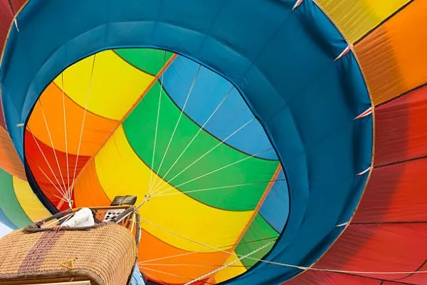 Globo aerostático en el aire rodeado de paisajes naturales, volando con total estabilidad como parte de un vuelo seguro y placentero.