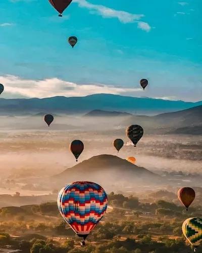 Many hot air balloons flying over the Teotihuacan pyramids, showing tourists who booked a hot air balloon Mexico City the magnificent views it offers.