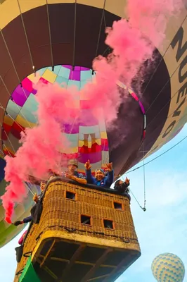 Happy group celebrates birthday with smoke, discovering how high a hot air balloon can go over landscapes.