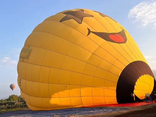 The preparation phase beautifully explains how does a hot air balloon works with a yellow balloon inflating gracefully.