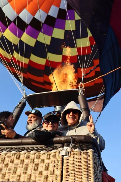 Personas disfrutando del amanecer mientras experimentan las 5 cosas que aprendes al volar en globo sobre paisajes impresionantes.