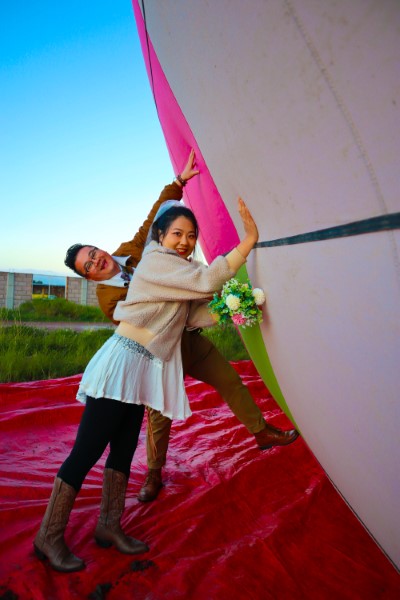 Two Asian travelers celebrate a special anniversary as they prepare to enjoy a romantic hot air balloons flight at sunrise.