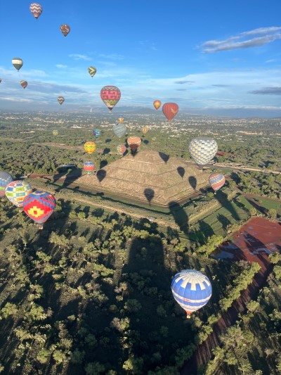 Aerial view of balloons flying over the pyramids, showcasing an unforgettable balloon trip with historic scenery, safe and organized.