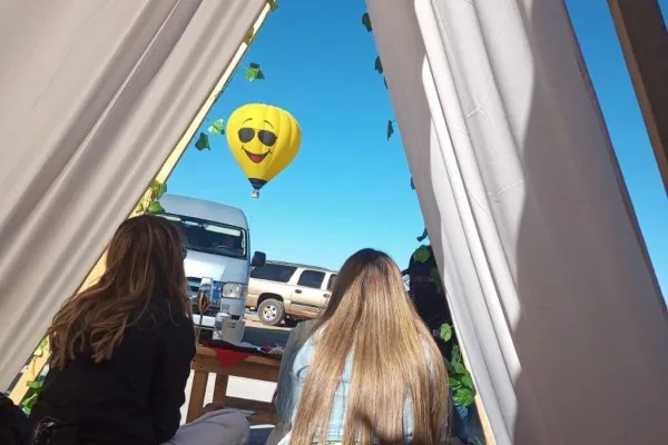Two friends eagerly awaiting the start of their adventure during a hot air balloon ride for two.