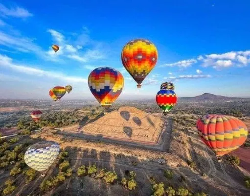 Turistas contemplando vistas panorámicas desde globos aerostáticos CDMX en vuelo matutino rodeado de tranquilidad y naturaleza.