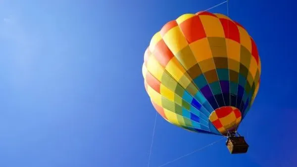 Globo aerostático colorido sobrevolando Teotihuacán durante amanecer espectacular con increíble precio vuelo en globo para turistas aventureros.
