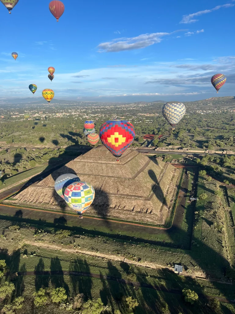 Globos aerostáticos sobrevuelan las pirámides durante vuelo en globo desde CDMX con transporte al amanecer para un momento mágico.