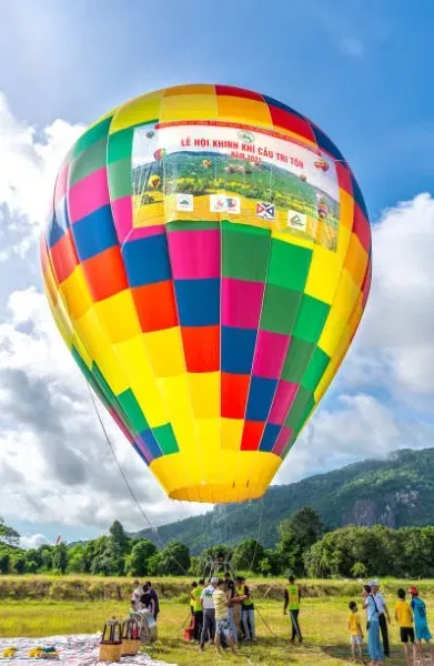 Visitantes observan globos preparándose al amanecer en el globopuerto, antes de iniciar una emocionante experiencia aérea segura.