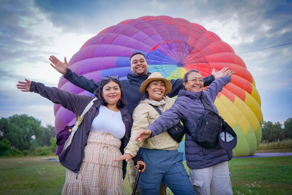 A smiling family poses in front of the balloon during the best time of year for hot air balloon flights in Teotihuacán.