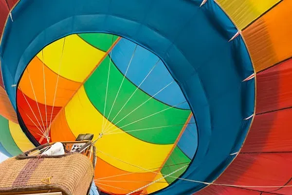 Colorido globo aerostático elevándose suavemente durante el amanecer, brindando una experiencia de vuelo seguro y memorable.