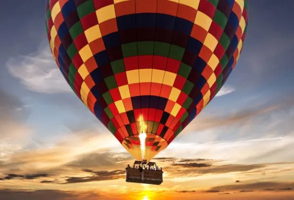 Pasajeros disfrutan el amanecer sobre Teotihuacán mientras aprenden cómo funciona un globo aerostático durante un vuelo seguro e inolvidable.