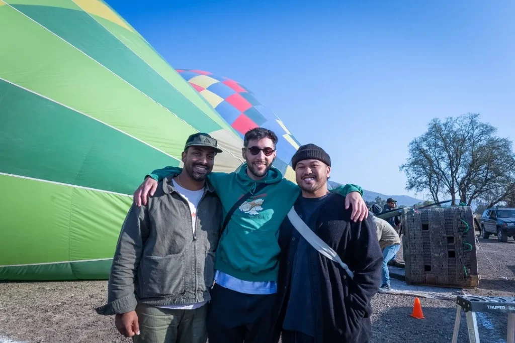 Three foreign friends wait to board a hot air balloon to admire Teotihuacán from the sky during an unforgettable sunrise.